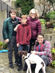 Connor now Otis with two smiling kids and two smiling adults in front of stairs leading to a home