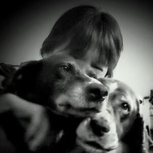 A black and white photo of the faces GSP Hazel and Springer Spaniel Caper, with the forever mom behind them