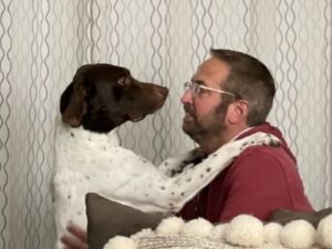 Adam success story pic, with Adam with his paws on his forever dad's shoulders